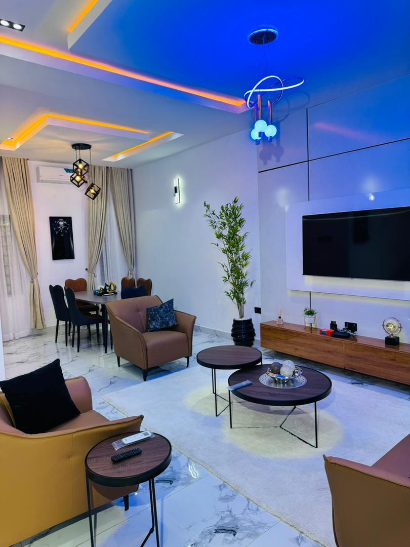 A living room lit in blue, with a long console and a television